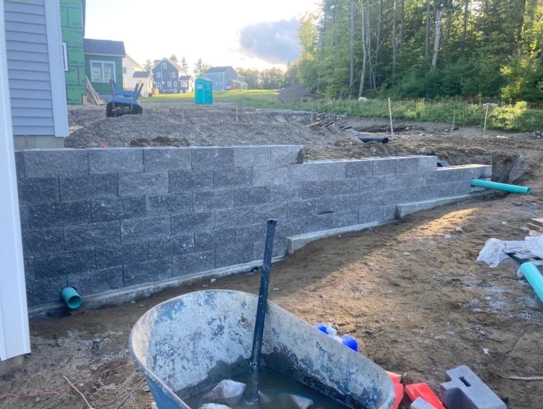 Segmental block retaining wall with drainage at a new construction site