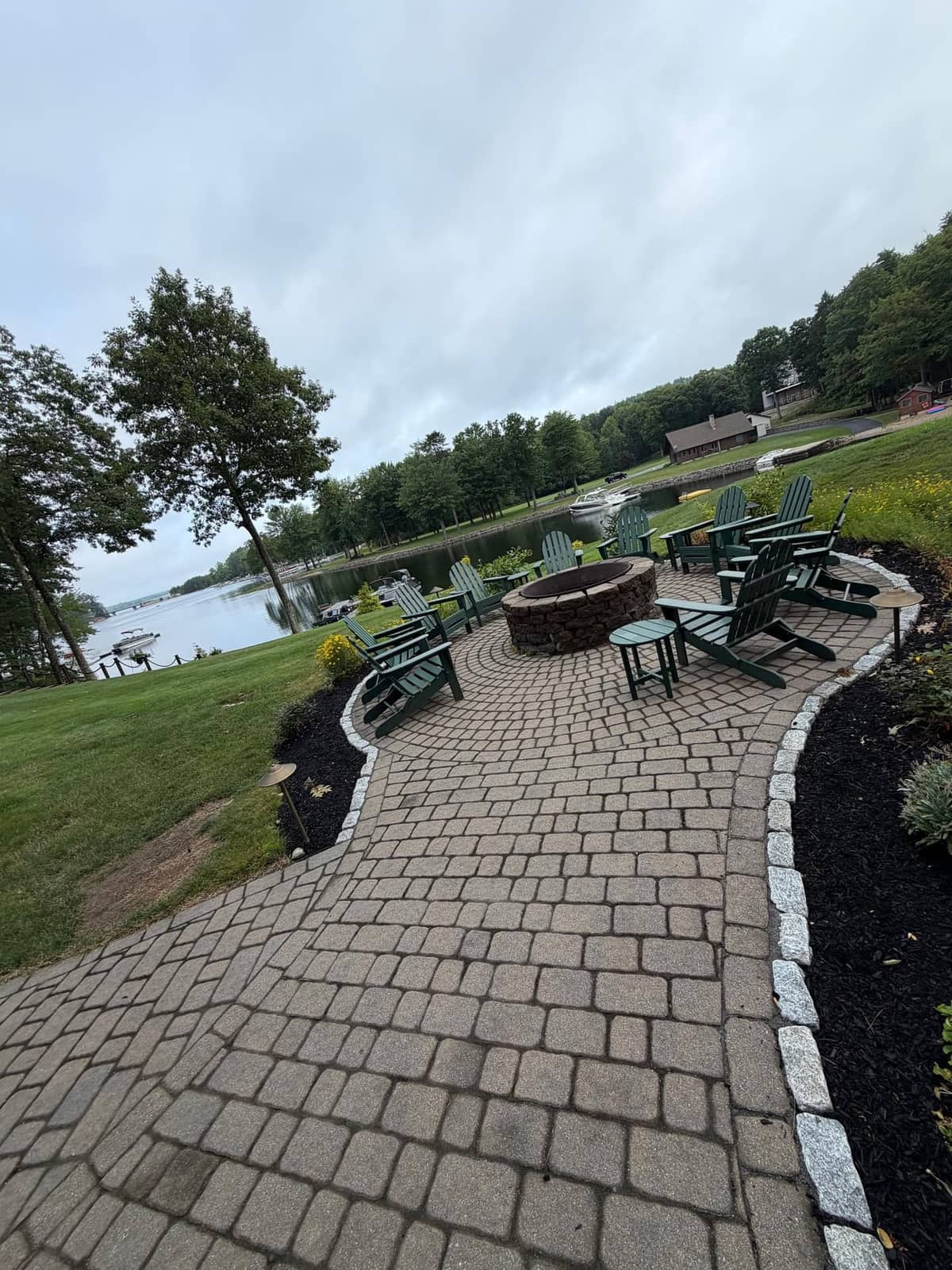 Curved paver patio with granite cobble border and fire pit at the waterfront