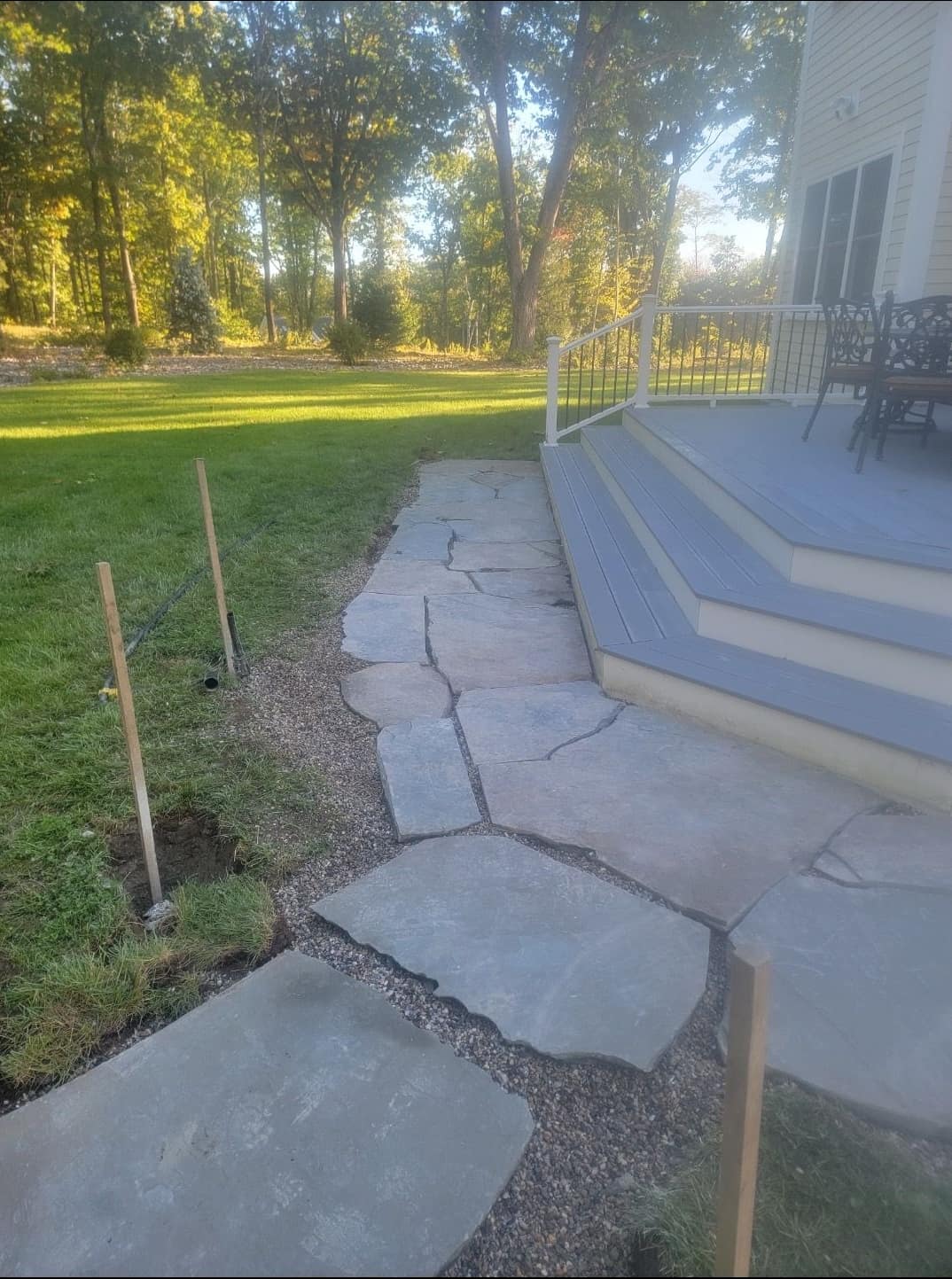 Flagstone walkway wrapping composite deck steps