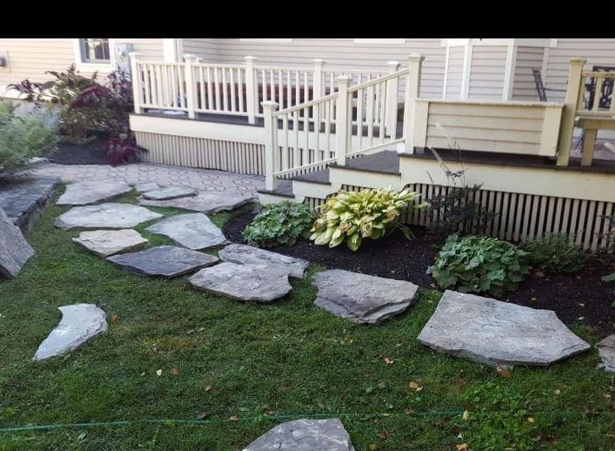Natural stepping stones through a garden bed beside a porch