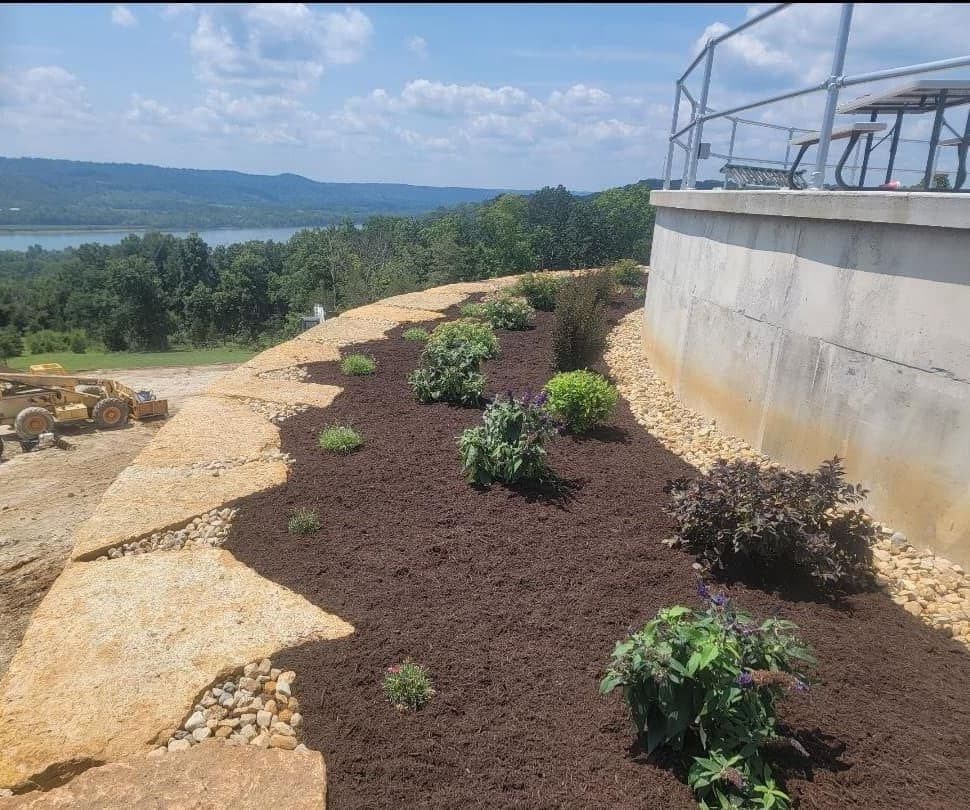 Hillside mulch bed with new shrubs overlooking a river valley