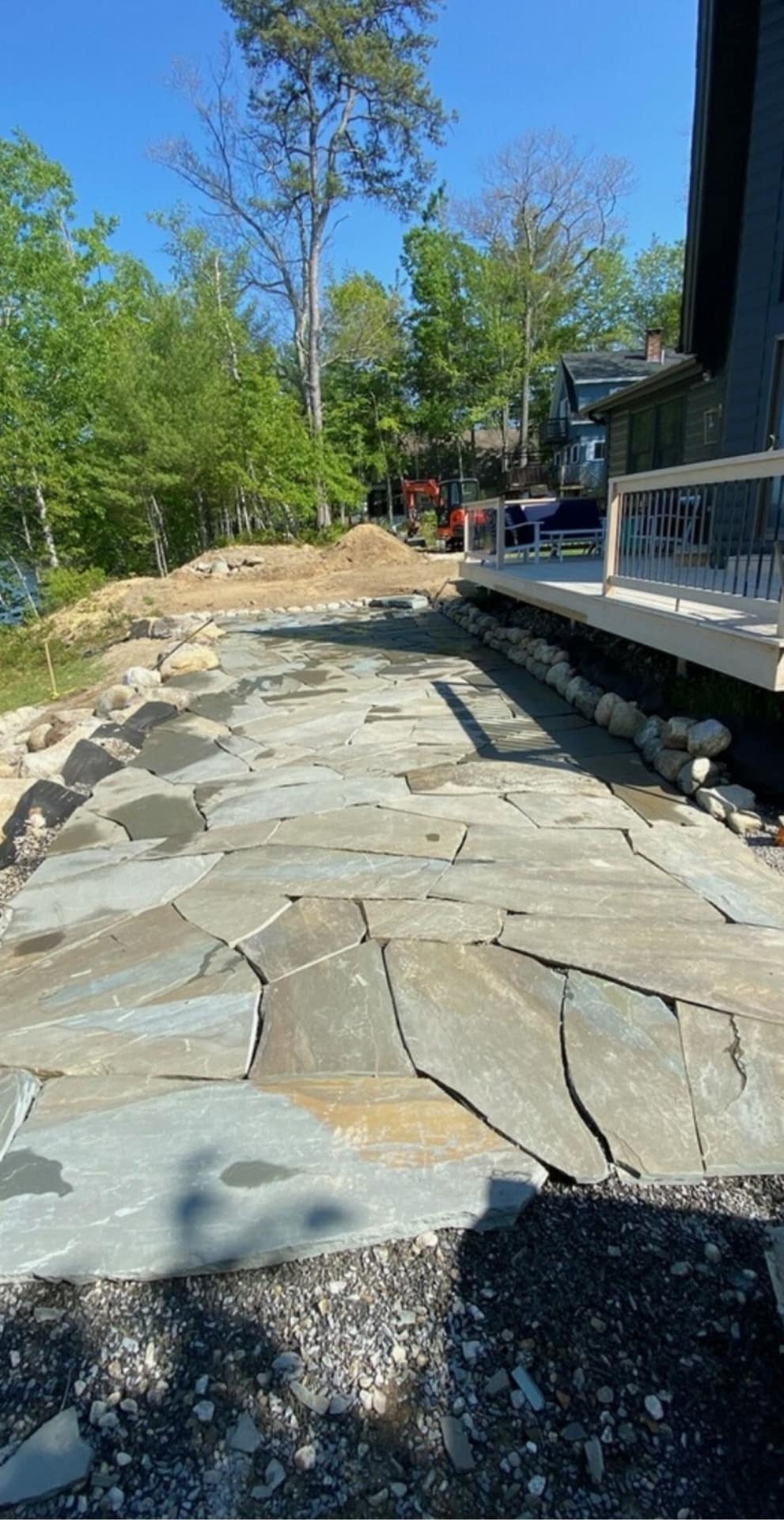 Flagstone path with boulder edge running beside a lakeside deck