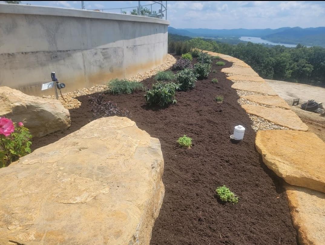 Mulched planting bed framed by large natural boulders